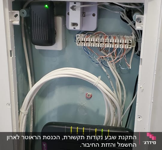 ארון תקשורת עם נתב, כבלים ומחבר רשת